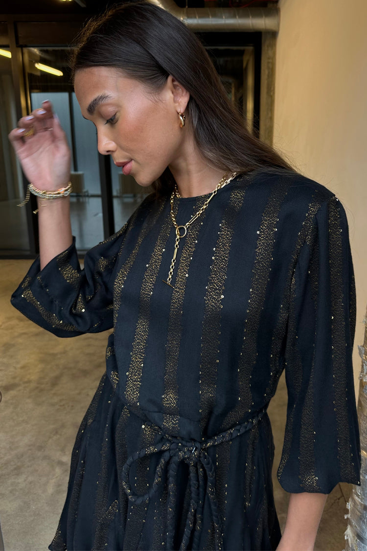 Model wearing Black And Gold Riri Dress