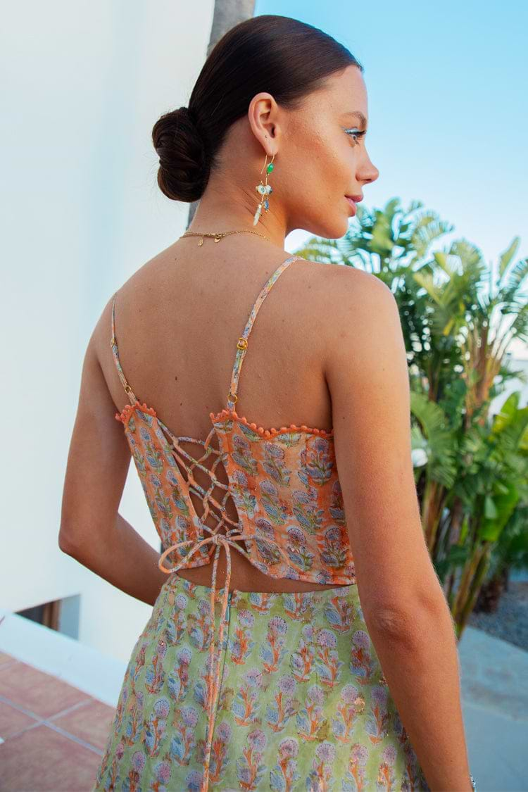 Model wearing Pink And Green Peony Dress facing away from the camera 