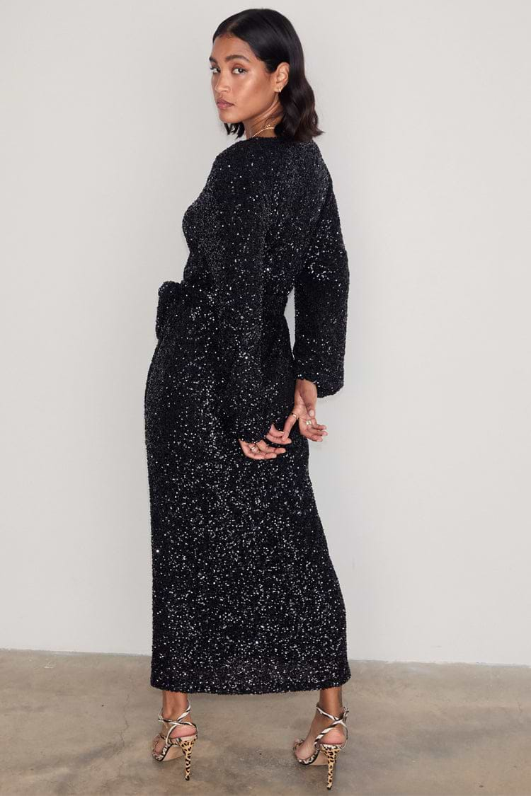 caption_Model wears Black Sequin Kira Wrap Dress in UK size 10/ US 6