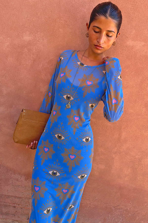 Abito maxi in rete Blue Eye con motivi a cuore, pochette color cuoio e gioielli dorati.