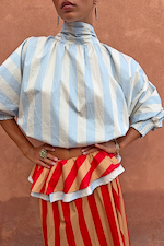 Blue Stripe Batwing Blouse with a high neck and voluminous sleeves, styled with a red and tan striped skirt.