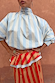 Blue Stripe Batwing Blouse with a high neck and voluminous sleeves, styled with a red and tan striped skirt.