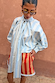 Blue Stripe Batwing Blouse with voluminous sleeves and a high tie neck, styled with red and tan striped shorts.