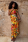 Rio A-Symmetric Skirt in a vibrant tropical fruit print styled as a co-ord against a textured wall.