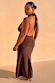 Model wearing Chocolate Sabine maxi dress with a halter neck tie, open back, and split back hem.