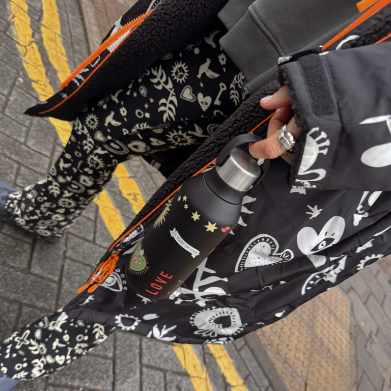 close up of our hope charcoal flare leggings and changing robe with the nfdxchilly's bottle