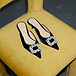 Navy velvet denim mules with silver embroidery on a yellow chair