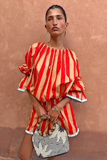 Model wearing the red and camel Tomato Stripe Blouse with voluminous flared sleeves and matching shorts.