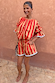 Model wears the red and camel Tomato Stripe Blouse with voluminous sleeves and matching shorts.