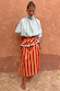 Tomato Stripe multi-wear dress in red and camel with light blue ruffles and a high neck.