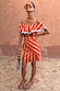 Tomato Stripe Scarf worn as a red and beige off-the-shoulder multi-wear dress on a model.