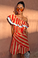 Model wearing the red and beige striped Tomato Stripe Scarf with oversized sunglasses.