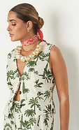 close up of our green palm waistcoat paired with the matching trousers and a chunky shell necklace 