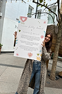 lucy holding a billboard of our collaboration with porto & bello