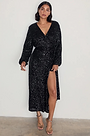 model is wearing the black sequin wrap dress