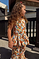 Young girl wearing a cream cotton peplum top and flared trousers with a multicoloured banana print.