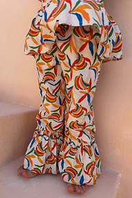 Pantaloni in cotone da bambina con stampa a banane multicolore, orlo con volant e top a peplo coordinato.
