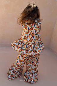 Coordinato in cotone da bambina crema con stampa a banane, top smanicato con peplo e pantaloni a zampa.