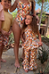 Girl wearing the multi-coloured banana print cotton co-ord set with a peplum top and flared trousers on vacation.