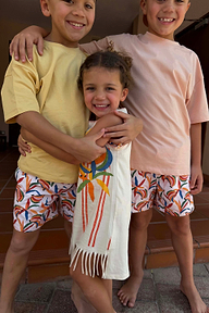Abito smanicato panna in cotone con stampa banane e frange, insieme a bimbi in shorts coordinati.