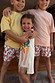 Sleeveless cream banana print cotton dress with a fringe hem, styled with kids in matching banana shorts.