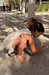 Girl wearing the cream banana print jersey cotton dress with fringe detail, playing outdoors in the sand.
