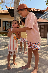 Shorts da mare da bambino con stampa a banane multicolore in poliestere riciclato, indossati in vacanza.