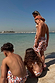 Boy's Banana Print Swim Shorts in cream with multi-coloured patterns, worn by children on a sunny beach vacation.