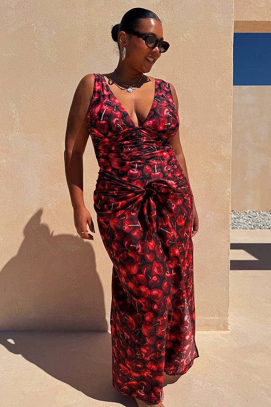 Sarong Black Cherry con stampa a ciliegie rosse e top coordinato indossato da una modella al sole.