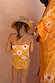 Back view of the Girl's Yellow Sun Swimsuit with a sun print, frill leg details, and cross-back straps.