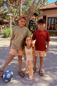 Girl in a yellow sun cotton vest and trousers set with soleil motifs, smiling on a sunny vacation.