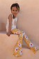 Girl sitting on stone stairs wearing a Yellow Sun Cotton Set with a sleeveless soleil vest and flared trousers.