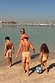 Girl's Yellow Sun Swimsuit with frill detailing and sun print, worn on a family beach vacation.