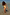 Thumbnail for Yellow sun print swimsuit with soft frill trims worn by a young girl standing in shallow water at the beach.