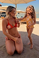 Girl's yellow sun-printed swimsuit with frill detailing on a beach vacation with a matching adult bikini.