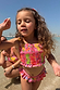 Pink Fruit Crop Bikini Set featuring Mediterranean-inspired prints and a shirred top on a sunny beach.