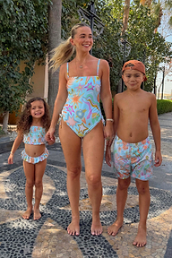 Girl wearing the blue Starburst crop bikini set with a smocked top and frill trim for a family vacation.