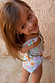 Girl wearing blue Starburst Crop Bikini Set with smocked frill top and celestial motifs.