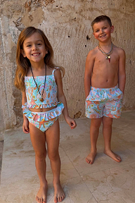 Young girl wearing a blue Starburst smocked crop bikini set with frill trims and a colourful dreamer print.