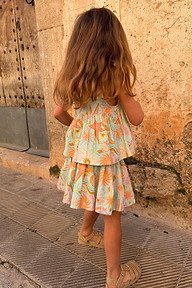Back view of a girl wearing the blue cotton Starburst Skirt Co-ord Set with a peplum top and tiered skirt.