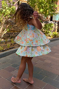 Girl wearing a blue cotton Starburst skirt co-ord set with pink sun and star motifs.