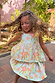 Young girl spinning in the blue Starburst Skirt Co-ord Set with peplum top and tiered sun and star print skirt.