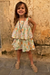 Girl wearing the blue Starburst cotton co-ord set with sun and star motifs against a stone wall.