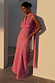 Pink Sophie maxi dress with gold fleck and multi-wear scarf on a model leaning against a white pillar.
