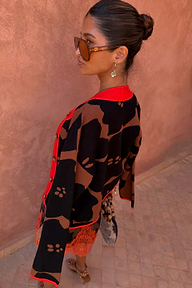 Tan Jaden Floral Jacquard cardigan with black floral patterns and red trim worn by a model.