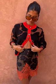 Tan Jaden floral jacquard cardigan with red trim, styled with a matching lace-trimmed skirt.