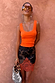 Maeva Mini Skirt in Tan Jaden Floral Print featuring an orange lace hem, paired with a bright orange ribbed vest.