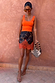 Maeva Mini Skirt in Tan Jaden Floral Print with orange lace trim, styled with an orange tank top.