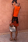 Maeva Mini Skirt in Tan Jaden Floral Print featuring orange lace trim, styled with an orange tank top.