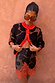 Model wearing Maeva Mini Skirt in Tan Jaden Floral Print with orange lace trim and matching knit cardigan.